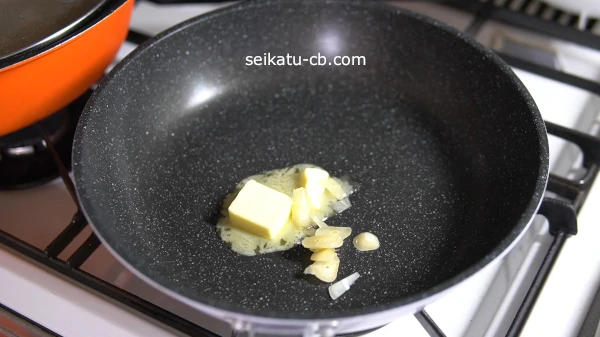 フライパンでバターとにんにくの薄切りを炒める