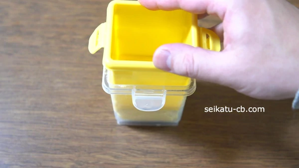 膨らんだ卵を黄色の容器と手で押さえて形を整える
