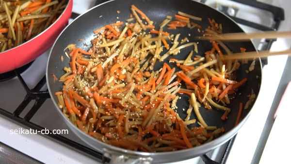 炒めたきんぴらにごま油と白ごま、一味唐辛子を加えて混ぜ合わせる