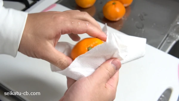 洗ったみかんの水けをふき取る