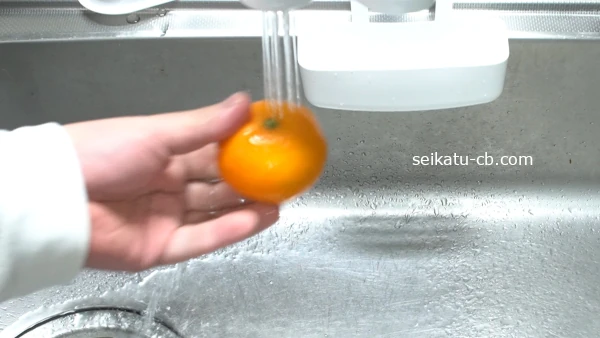 冷凍したみかんをいったん取り出し水をかける