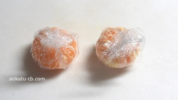 皮をむいたみかんをラップで包む