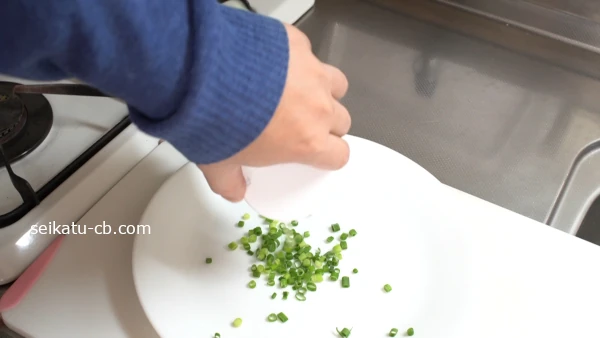 シャカシャカねぎポットのふたを開けて冷凍した刻みねぎを皿の上に出す