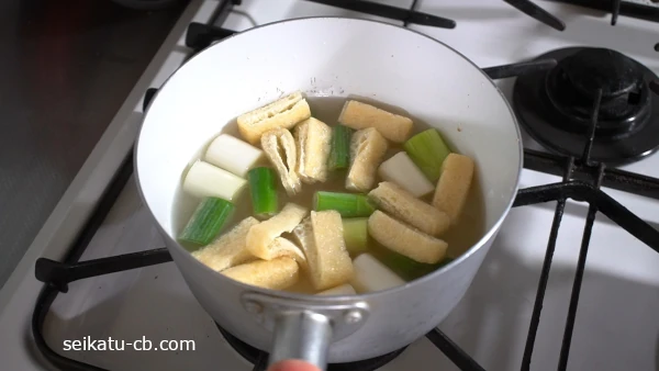 鍋に水と顆粒だし、長ねぎと油揚げを入れて火にかける