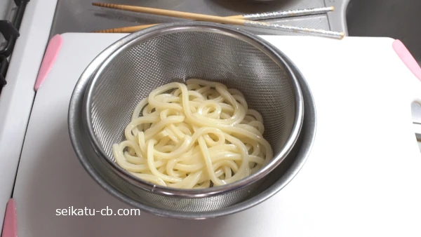 茹でたうどんをざるに上げる