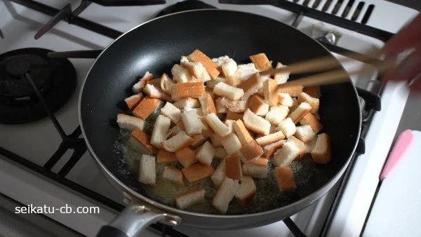 フライパンに食パンの耳も加えて弱火で炒める