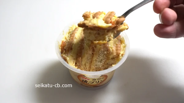 ビスケットを差し込んで作った焼きプリンデザートをスプーンですくう
