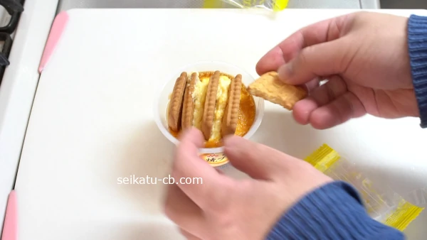 バタービスケットを半分に割って焼きプリンに差し込む