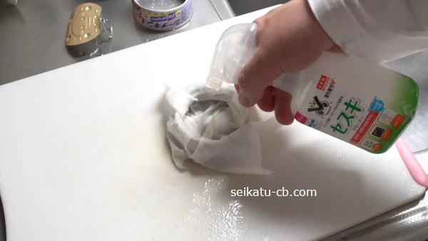 水で洗ったツナ缶をキッチンペーパーで包み、上からセスキ水をかけて5分置いておく