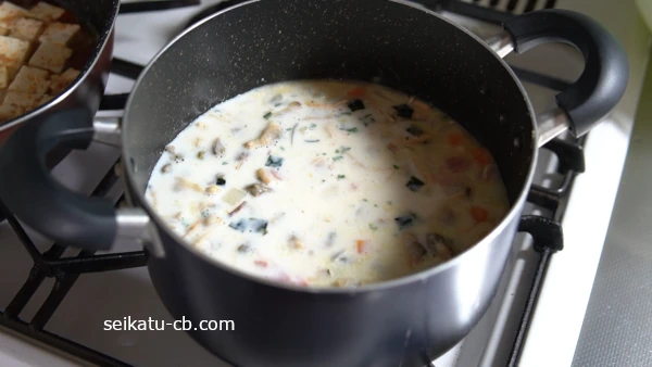 鍋に冷凍むきあさりと牛乳、松茸の味お吸い物2袋を入れて一煮立ちさせる